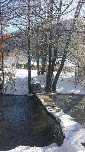 a walkway next to a river in the snow at Staparski Sorrento in Užice
