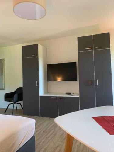 a room with a bed and a desk with a tv at Mare Balticum Urlaub auf Rügen in Sagard