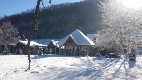 a log cabin in the snow with snow covered trees at Staparski Sorrento in Užice