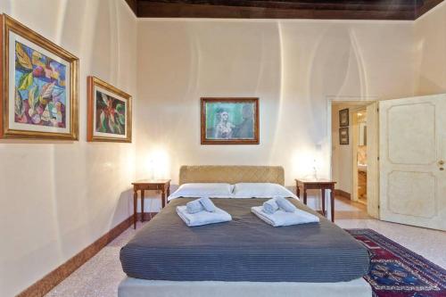 a bedroom with a large bed with two towels at Doge Palace Luxury Apartment - Cannaregio in Venice