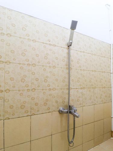 a shower in a bathroom with a tile wall at RedDoorz At Merdeka Street Garut in Garut