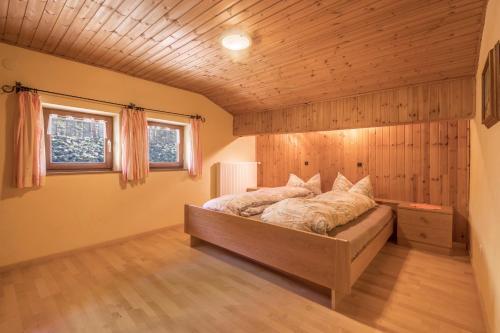 a bedroom with a bed in a room with wooden walls at Untervernatsch Fewo Edelweiss in Senales