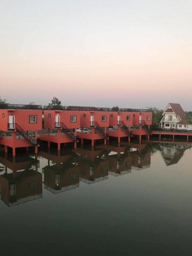 a row of houses on a body of water at Rung ChiangRai Resort in Chiang Rai