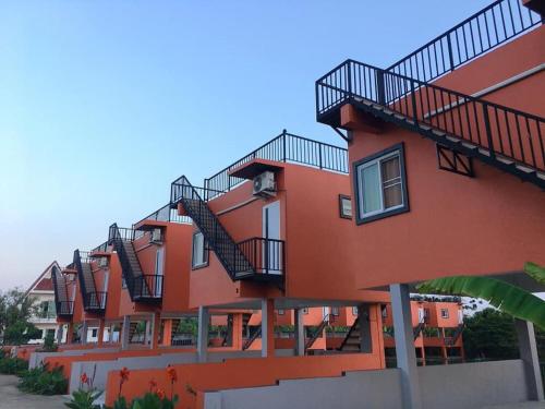 an orange building with stairs on the side of it at Rung ChiangRai Resort in Chiang Rai