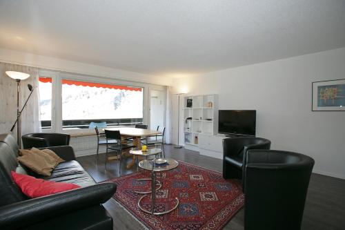 a living room with a couch and a table at Apartments Haus Quelle in Leukerbad