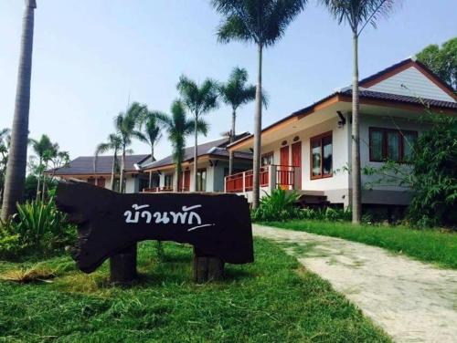 a sign in the grass in front of a house at Resort Railumpoo (Farm and Camping) in Nakhon Sawan
