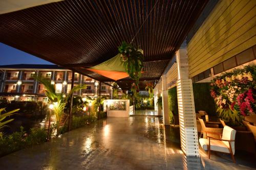 a porch of a building with flowers and plants at KT Knight Hotel in Surin