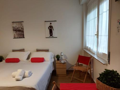 una camera da letto con due letti, una sedia e una finestra di Bnbook-Ughelli a Rho