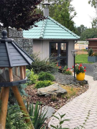 a garden with a small building with a roof at Penzion Merica in Bor