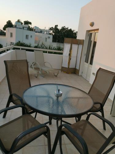 a glass table and chairs on a balcony at Garden Luxury Apartment Ayia Napa in Ayia Napa