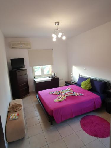 a bedroom with a pink bed with a pink blanket at Garden Luxury Apartment Ayia Napa in Ayia Napa