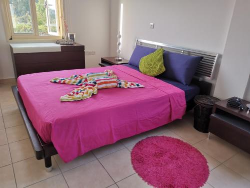 een slaapkamer met een roze bed en een roze deken bij Garden Luxury Apartment Ayia Napa in Ayia Napa