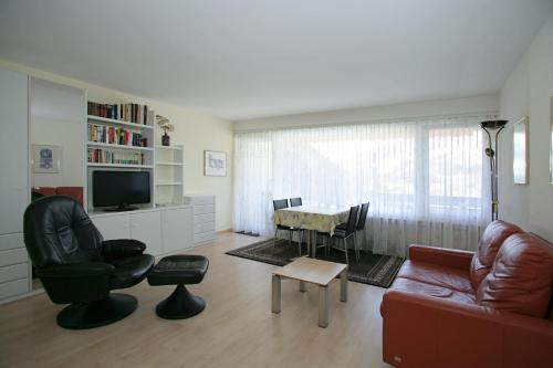 a living room with a couch and a table at Apartments Haus Quelle in Leukerbad