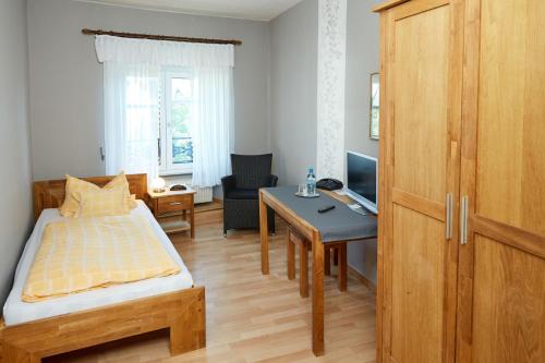 Schlafzimmer mit einem Bett, einem Schreibtisch und einem Tisch in der Unterkunft Hotel-Restaurant Maas in Lutzerath