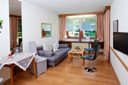 a living room with a couch and a table at Hotel-Restaurant Maas in Lutzerath