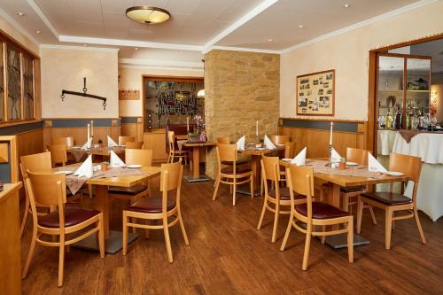 a dining room with wooden tables and chairs at Hotel-Restaurant Maas in Lutzerath
