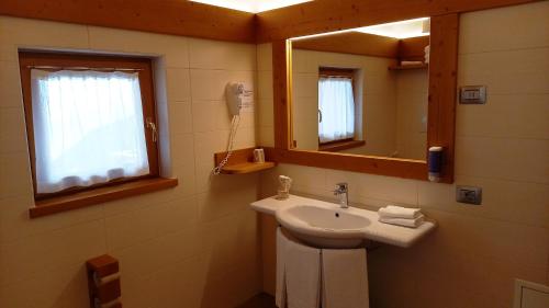 bagno con lavandino e specchio di Hotel Monte Bondone a Vaneze