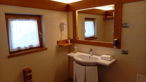 uma casa de banho com um lavatório e um espelho em Hotel Monte Bondone em Vaneze