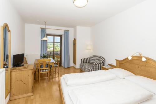 a bedroom with a bed and a desk and a chair at Appartements Eppanerhof in Appiano sulla Strada del Vino