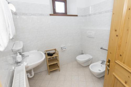 a white bathroom with a sink and a toilet at Appartements Eppanerhof in Appiano sulla Strada del Vino