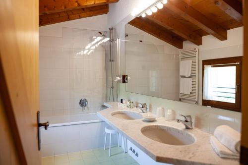 a bathroom with two sinks and a large mirror at Asolo Golf Club in Cavaso del Tomba