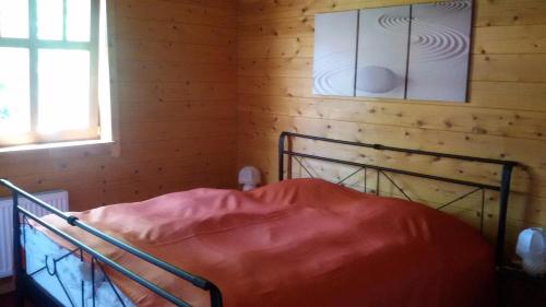 uma cama num quarto com uma parede de madeira em Reuken - Fewo Zum Emslotsen em Emden