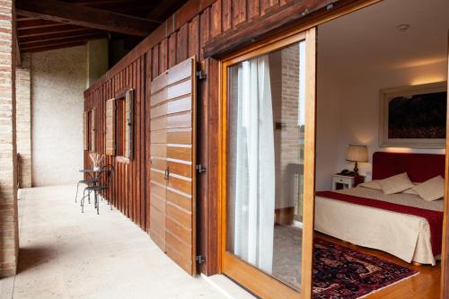 ein Schlafzimmer mit einem Bett und einer Glasschiebetür in der Unterkunft Asolo Golf Club in Cavaso del Tomba