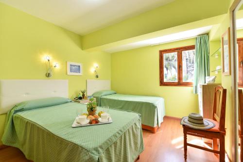 two beds in a room with green walls at Apartment Tindaya MT Maspalomas by VillaGranCanaria in Maspalomas