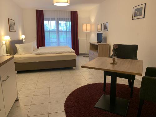 a bedroom with a bed and a table in a room at Mare Balticum Urlaub auf Rügen in Sagard