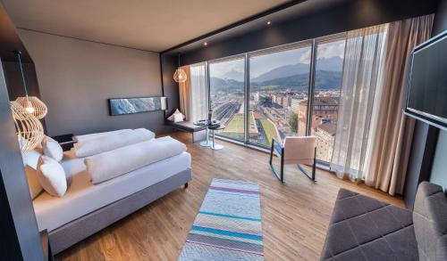 sala de estar con sofá y ventana grande en aDLERS Hotel Innsbruck en Innsbruck