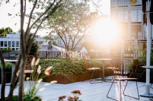 a patio with chairs and a table and the sun at THE FLAG West M. in Frankfurt/Main