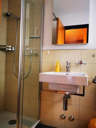 a bathroom with a sink and a shower at Apartments Haus Quelle in Leukerbad