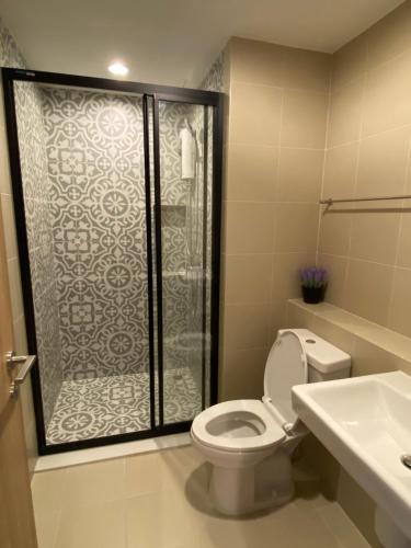 a bathroom with a shower and a toilet and a sink at La HABANA Condo 135/500 in Hua Hin