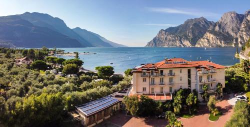 a building with a view of a lake and mountains at Hotel Baia Azzurra - Lake Front in Nago-Torbole