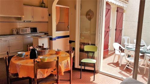 une cuisine avec une table avec des chaises et une salle à manger dans l'établissement Proche de la plage et des commerces joli pavillon 6 personnes-6VROUS5, à Saint Cyprien Plage