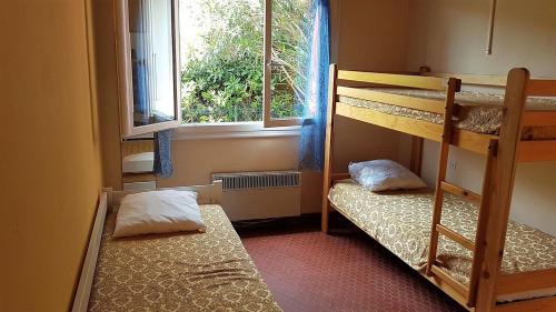 deux lits superposés dans une chambre avec fenêtre dans l'établissement Proche de la plage et des commerces joli pavillon 6 personnes-6VROUS5, à Saint Cyprien Plage