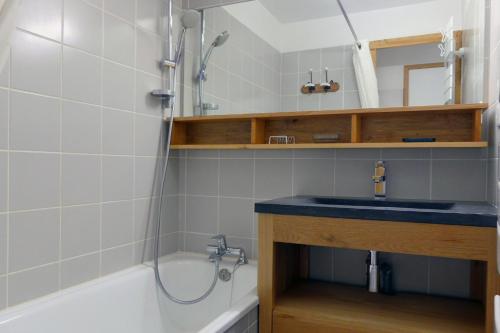 y baño con lavabo y bañera. en Apartment Sérac en Méribel