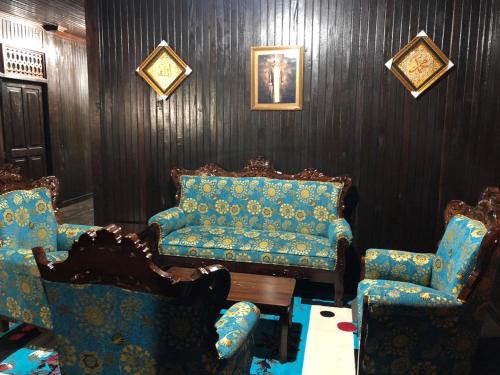 Mimi Guest House Syariah Pangkalan bun في بانكالان بون: غرفة معيشة مع أريكة وكرسيين