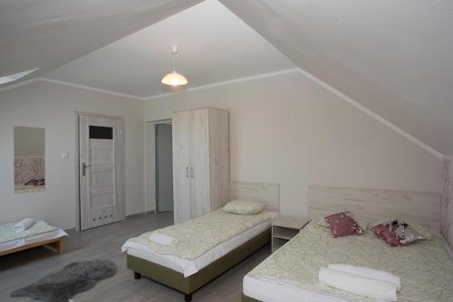 a white room with two beds and a closet at Pan Tadeusz in Zwierzyniec
