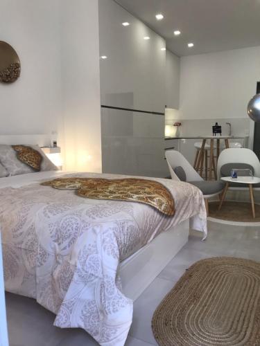 a white bedroom with a bed and a table and chairs at Viana é CORAÇÃO DE OURO in Viana do Castelo