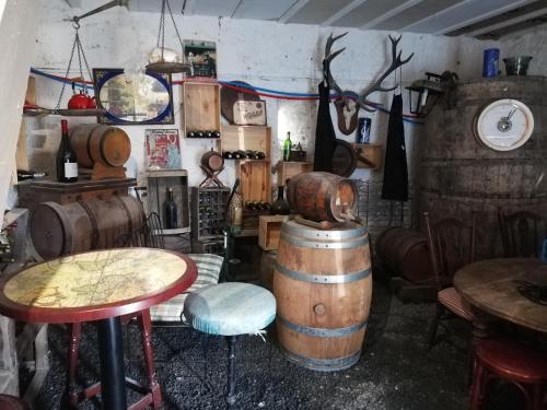 une chambre avec un tas de tables et un tonneau dans l'établissement D'ici et d'ailleurs, à Raids