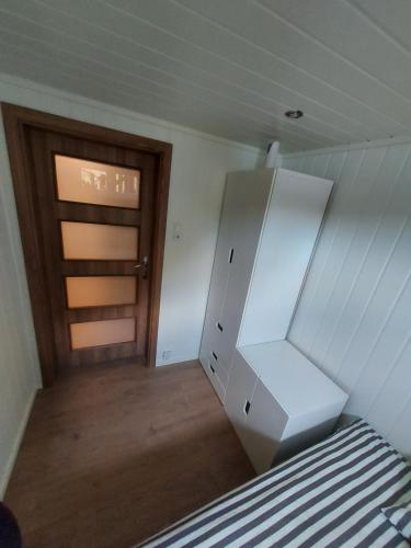 a white refrigerator in a room with a door at Bazyl Apartment in Folkedal