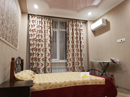 ゲレンジークにあるApartments Gelendzhik Krymskaya streetのベッドと窓が備わる小さな客室です。