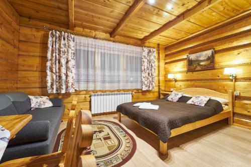 a bedroom with a bed and a couch in a room at Noclegi u Hanki in Bukowina Tatrzańska