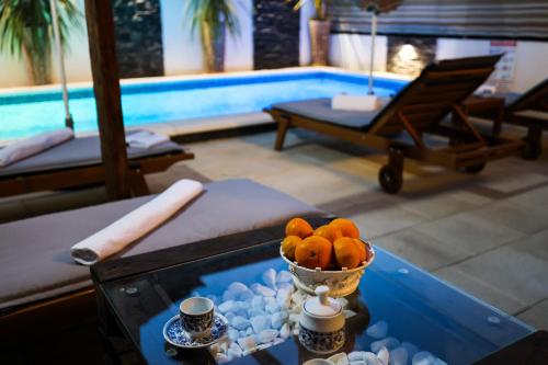 a table with a bowl of oranges on it next to a pool at Apartment Rustica Zadar with exclusive use of the pool-ground floor in Zadar