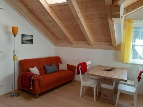 uma sala de estar com um sofá vermelho e uma mesa em Ferienwohnung Christine em Altaussee