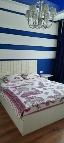 a bed in a room with blue and white stripes at SHANYRAK Гостевой дом in Aktobe