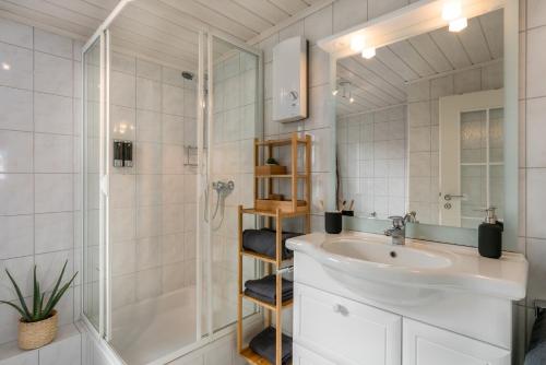 a white bathroom with a sink and a shower at FOREST & MOUNTAIN - 2min Bikepark, SNES, SSC, Bikegarage, Terrace in Winterberg