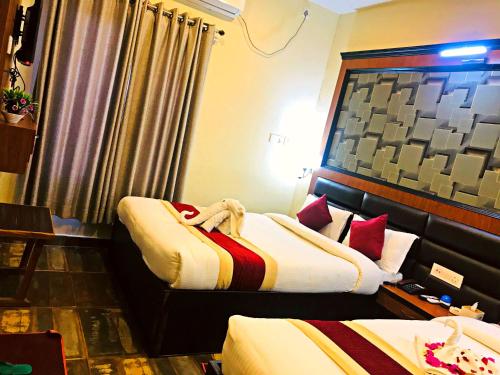 a room with two beds in a hotel room at Hotel the Narayani in Maruwā Ghāt