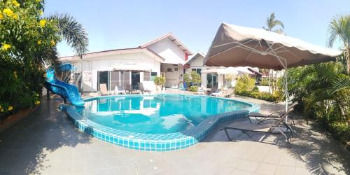 a swimming pool with a slide in front of a house at Baan Kaew Ruen Kwan in Jomtien Beach